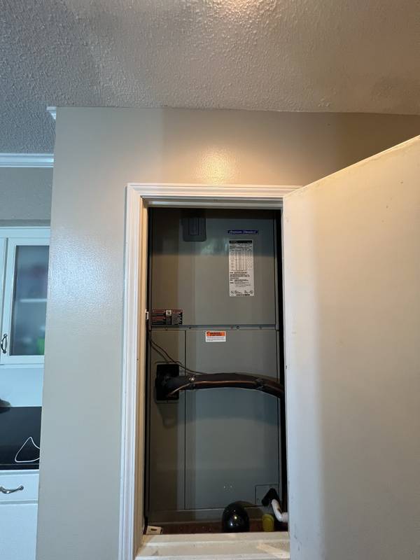 Air handler installed in an interior hallway closet with the door open