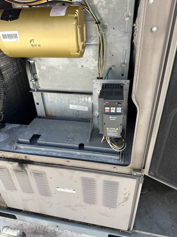 Inside a unit: a yellow blower motor beside a variable-speed drive and its wiring
