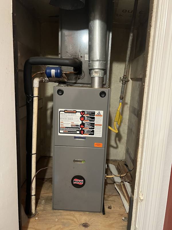 Gas furnace in a closet with its flue pipe and condensate line